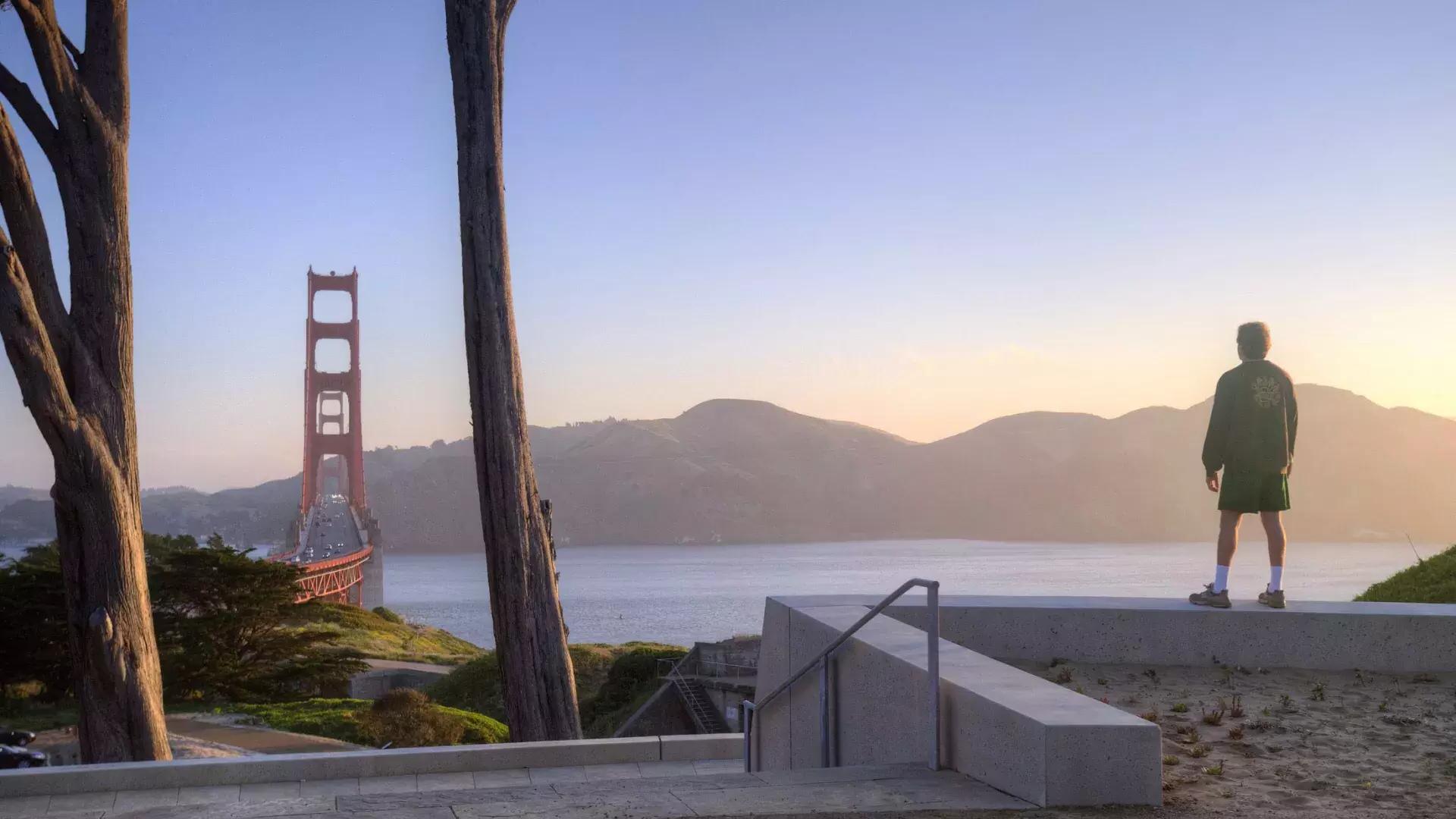 Un homme surplombe le Golden Gate Bridge avec les montagnes en arrière-plan.