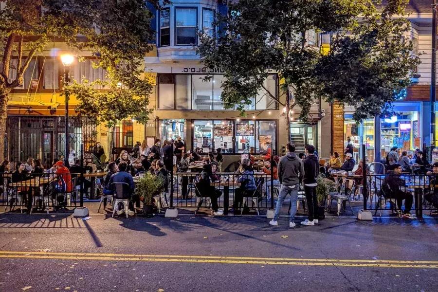 Una folla si gode cibo e bevande lungo Valencia Street a San Francisco